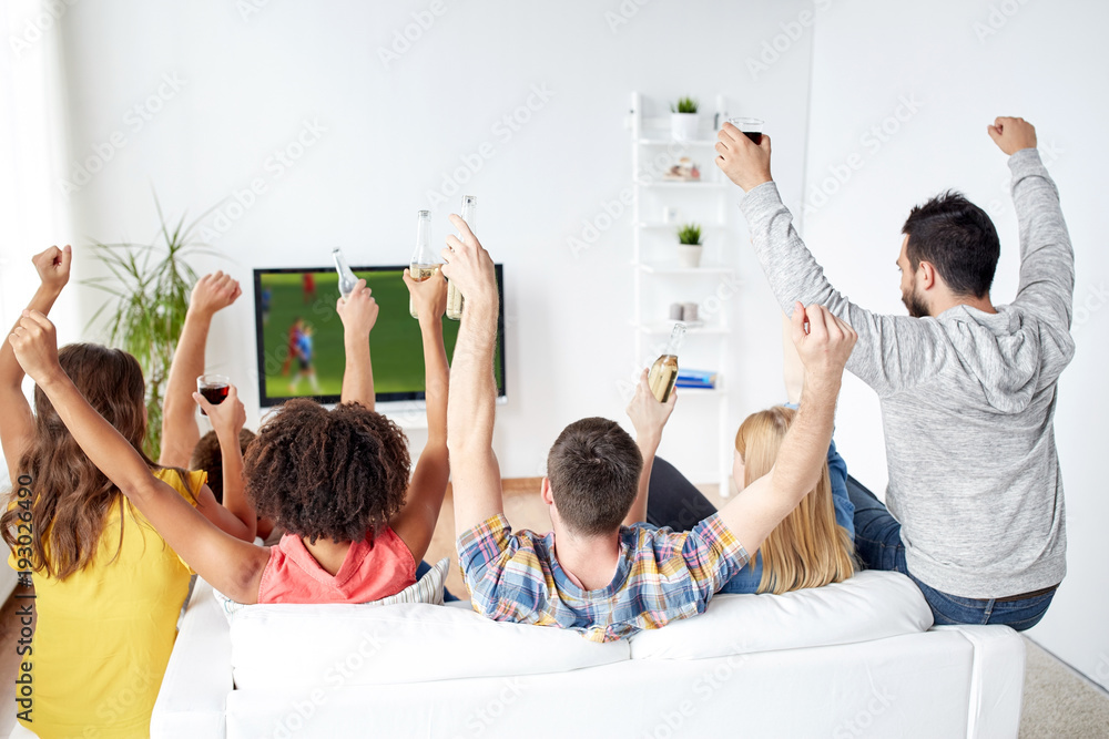 Wall mural friends watching soccer on tv and celebrating goal