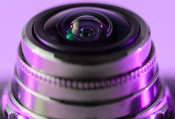 Fototapeta na wymiar Camera lens close - up backlit yellow-purple. Horizontal photo..