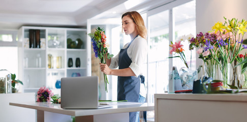 Female florist at work creating a bouquet