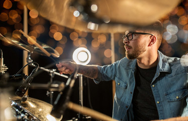 male musician playing drums and cymbals at concert