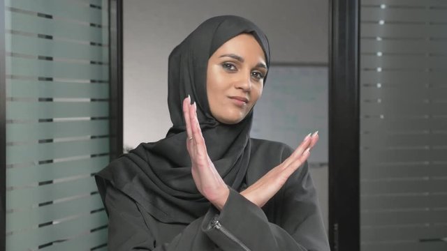 Portrait of Young woman in black hijab showing stop sign, Dislike, Rejecting Gesture, Disagree Sign, Crossing hands 60 fps