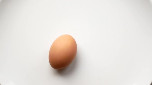 Egg rotation on a white background. concept of time, running on the spot