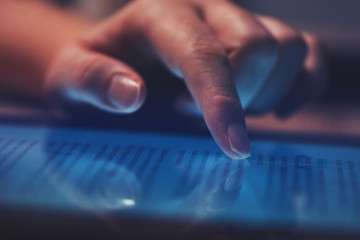 Extreme close up of female finger using digital tablet computer