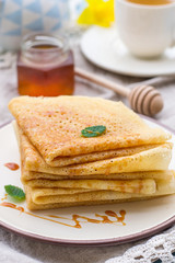 Stack of thin pancakes crepes with caramel topping