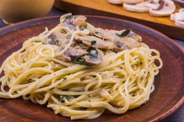 Spaghetti, Pasta with mushrooms in creamy sauce on a plate close up