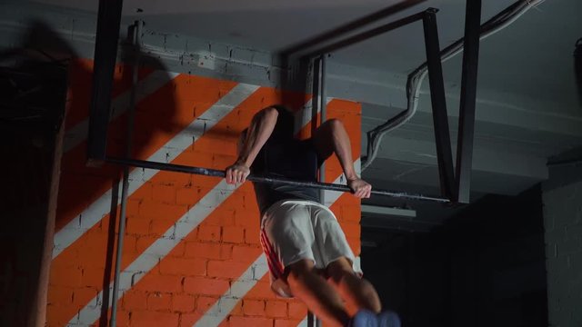 sportsman doing an exercise on a horizontal bar in the gym