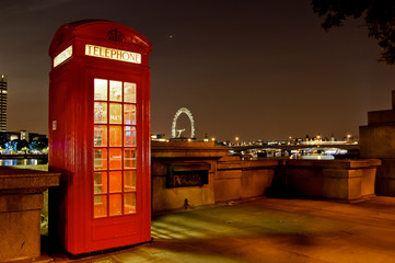 Traditional english phone booth with the London Center in the background