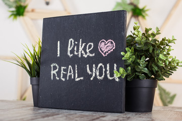 Black board with motivational inscription on the table. I like real you. Love motivation text.