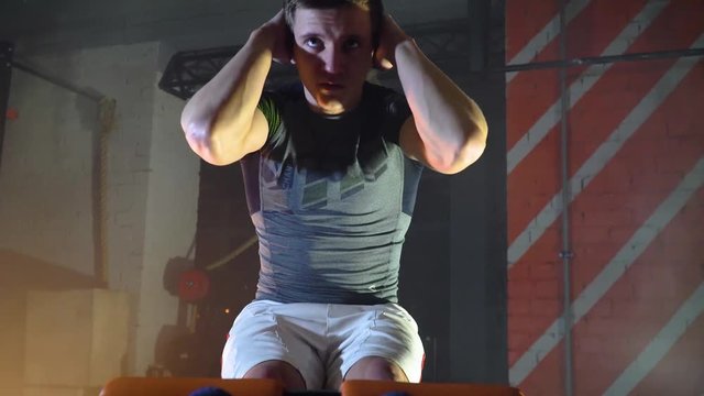 athlete does exercises for the press on the simulator