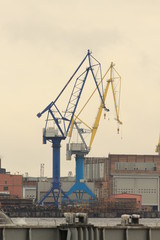two high harbor cranes on shore