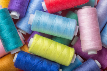 sewing thread in different colors pink blue green red