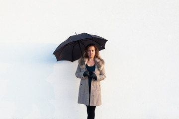 Curly beautiful  elegant woman holding umbrella on white background outdoor