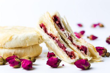 Rose pastry with natural flowers on white background