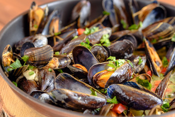 Plate of mussels with sauce and spices.