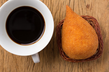 Coxinha is a deep fried food, traditional in Brazil. Snack and espresso coffee on rustic wood, flat design.
