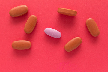 All tablets are red except one: pink. Red background.