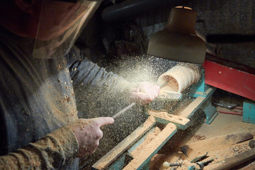 A man in the Studio hones wood blanks on a woodworking machine. turning wood on a lathe