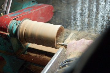 A man in the Studio hones wood blanks on a woodworking machine. turning wood on a lathe