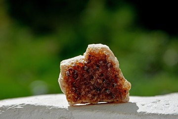 Brauner Mineralien Quarz Stein im Sonnenlicht vor grüner Natur