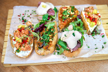 Board with tasty fresh bruschettas on table