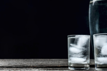 Cold vodka in shot glasses on a black background
