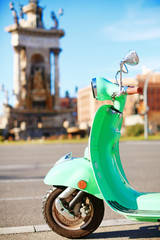 Vintage felgroene scooter geparkeerd in de straat van Barcelona op een zonnige dag