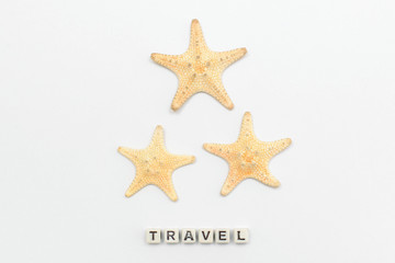 Three starfish on a white background with an inscription travel