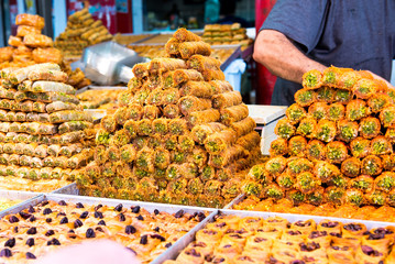 Variety of sweets on the arab street market stall. Eastern sweets in a wide range, baklava, Turkish...
