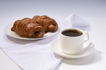 Coffee cup with croissant. Breakfast meal with fresh coffee and french pastry on white