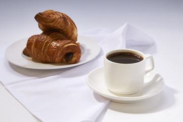 Coffee cup with croissant. Breakfast meal with fresh coffee and french pastry on white