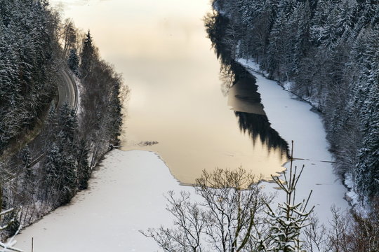 Aerial view of concrete Brezova dam with hydroelectric power plant and road to Karlovy Vary from Jungmann gazebo, snowy winter day, Czech Republic