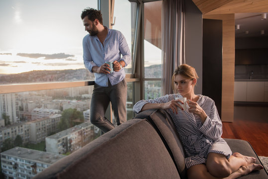 young couple enjoying evening coffee by the window