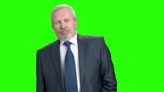 Confident elderly businessman, green screen. Senior caucasian business man looking displeased and nodding with head on chroma key background.