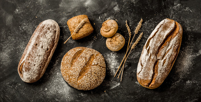 Bakery - rustic crusty loaves of bread and buns on black