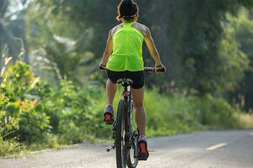 Fototapeta na wymiar fitness woman cyclist cycling mountain bike on tropical forest trail