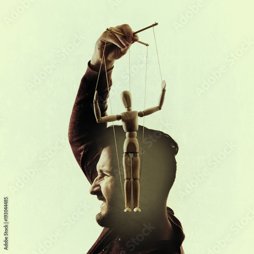 "Side view of man holding puppet of his head against white background