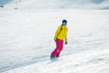 Photo of young athlete girl wearing helmet in sports clothes snowboarding