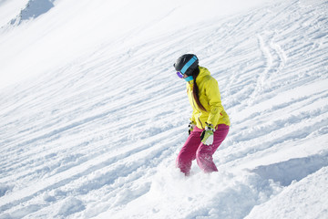 Fototapeta na wymiar Picture of athlete brunette in helmet and mask, snowboarding from snowy mountain slope