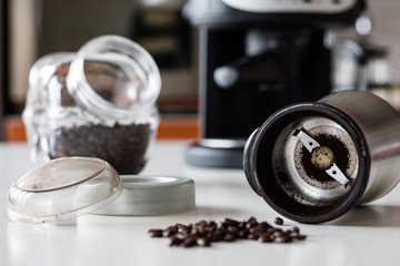 Morning coffee in the kitchen. Coffee grinder and coffee maker with coffee makers on a white kitchen table.