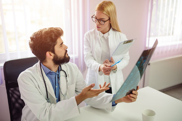 Obraz premium Male and female doctor having discussion in hospital. Doctors analyze x-ray.