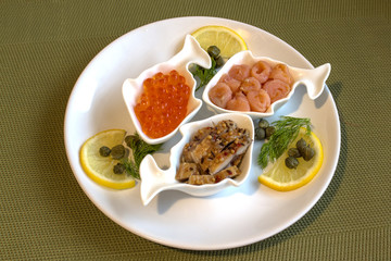 A plate of seafood with lemon, dill and capers.