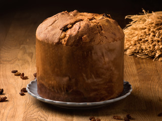 Panettone con pasas en una mesa de madera con luz cálida. 