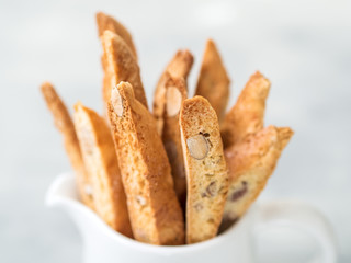 Biscotti (cantuccini) - traditional Italian almond dessert in white cup closeup.