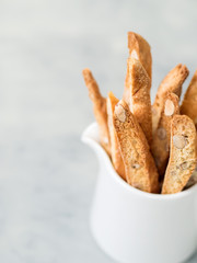 Biscotti (cantuccini) - traditional Italian almond dessert in white cup closeup.
