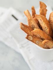Biscotti (cantuccini) - traditional Italian almond dessert in white cup closeup.