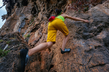 female rock climber climbing on steep cliff