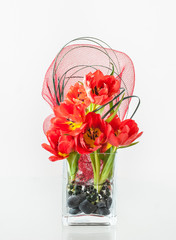 Decorative bouquet of red tulips in a glass vase