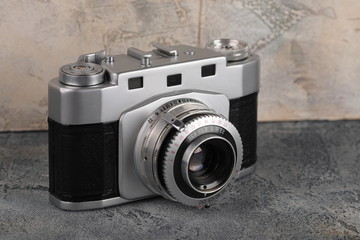 Old rangefinder film camera on a concrete background.