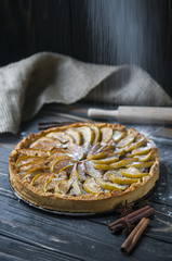 Baked apple pie, tart with falling flour cinnamon and star anice with sackcloth on dark wooden...