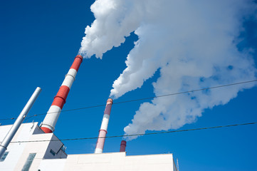 Air pollution by smoke coming from three factory chimneys